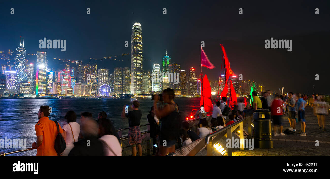 Il famoso quartiere Tsim Sha Tsui promenade e turisti che si godono la sera il panorama dell'Isola di Hong Kong, Hong Kong, Cina. Foto Stock