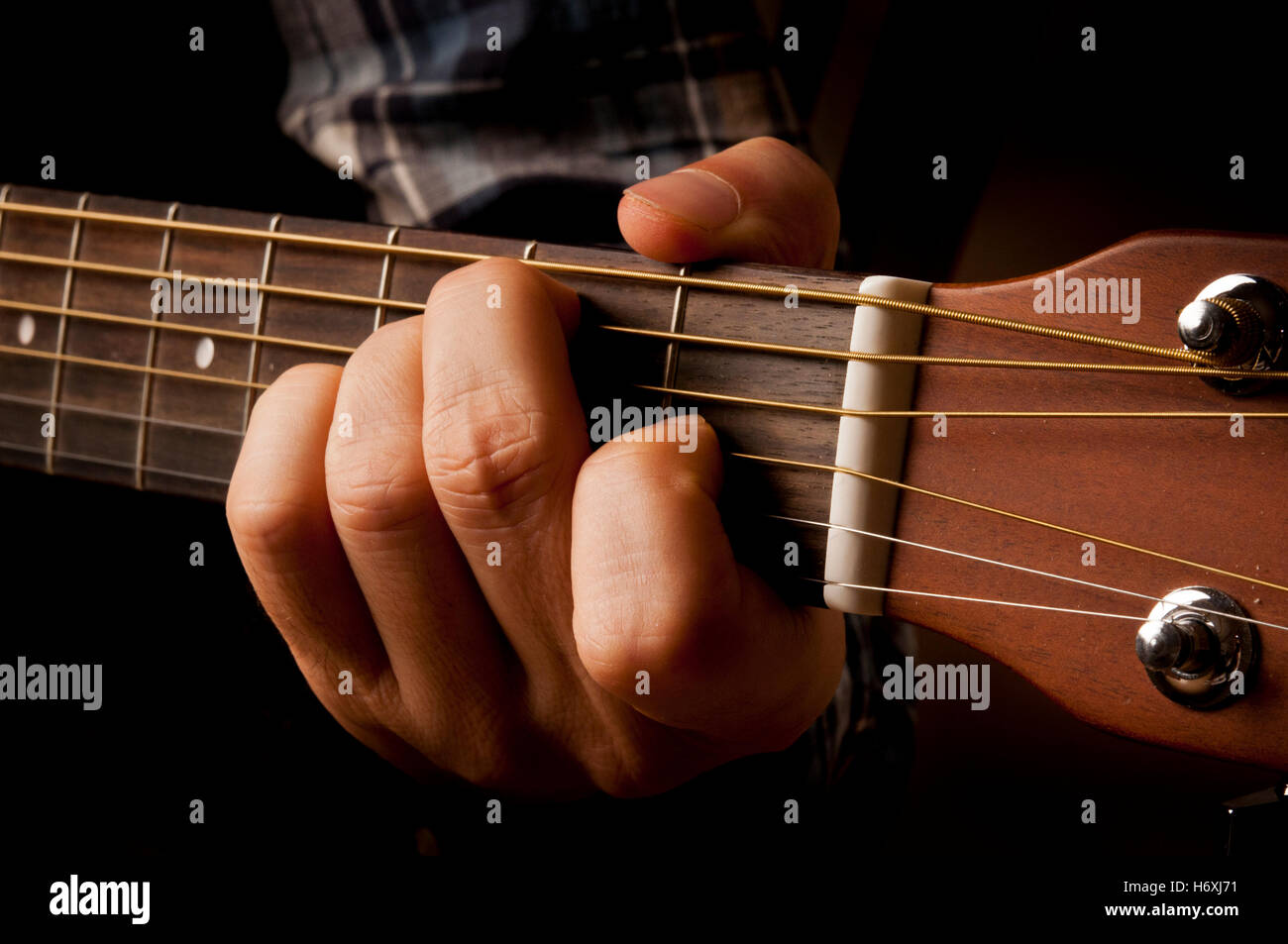 Mano di un chitarrista suonando una chitarra acustica Foto Stock