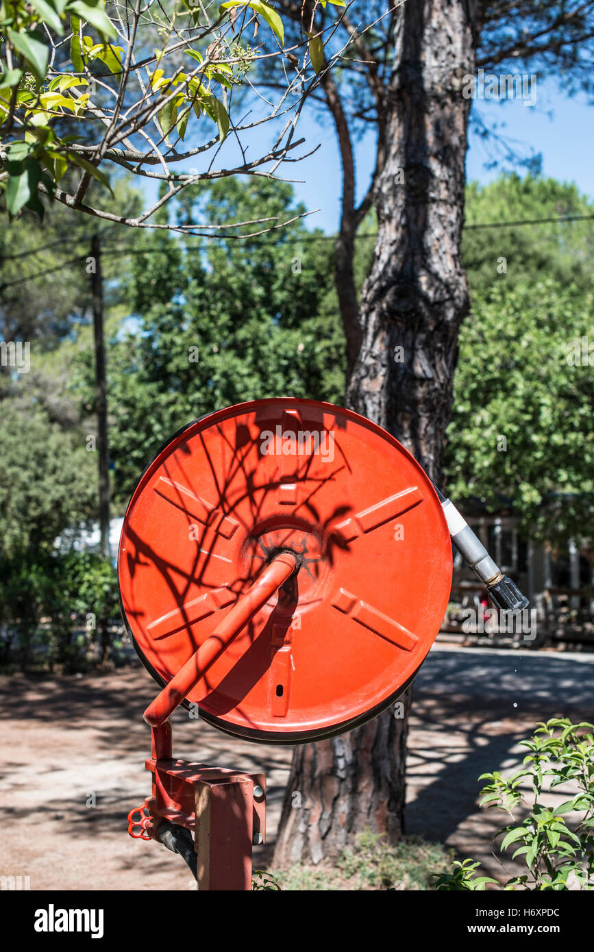 Estintore in un giardino. Alberi e case Foto Stock