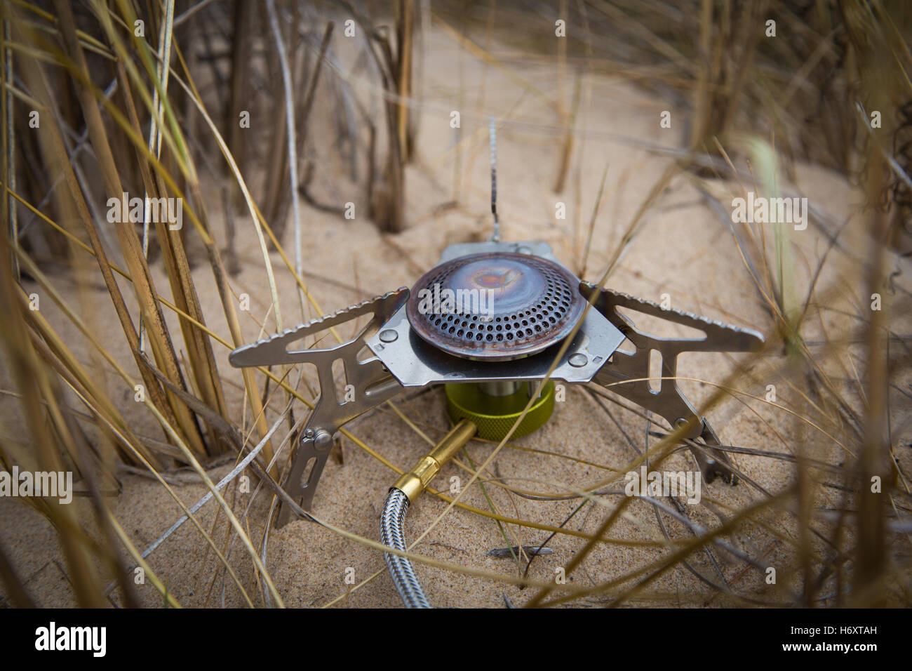 Camping fornello e pentola in spiaggia in erba Foto Stock