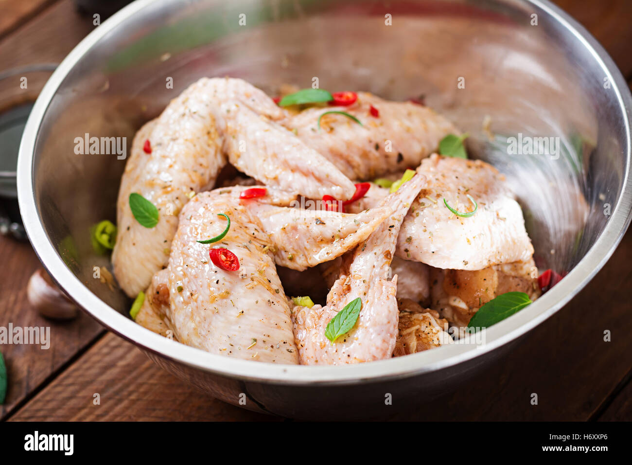 Materie marinato ali di pollo preparato in stile asiatico con il miele, aglio, la salsa di soia e le erbe aromatiche Foto Stock