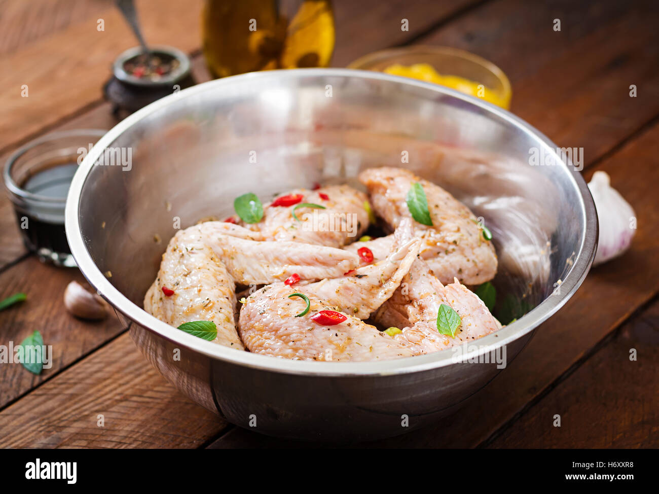 Materie marinato ali di pollo preparato in stile asiatico con il miele, aglio, la salsa di soia e le erbe aromatiche Foto Stock
