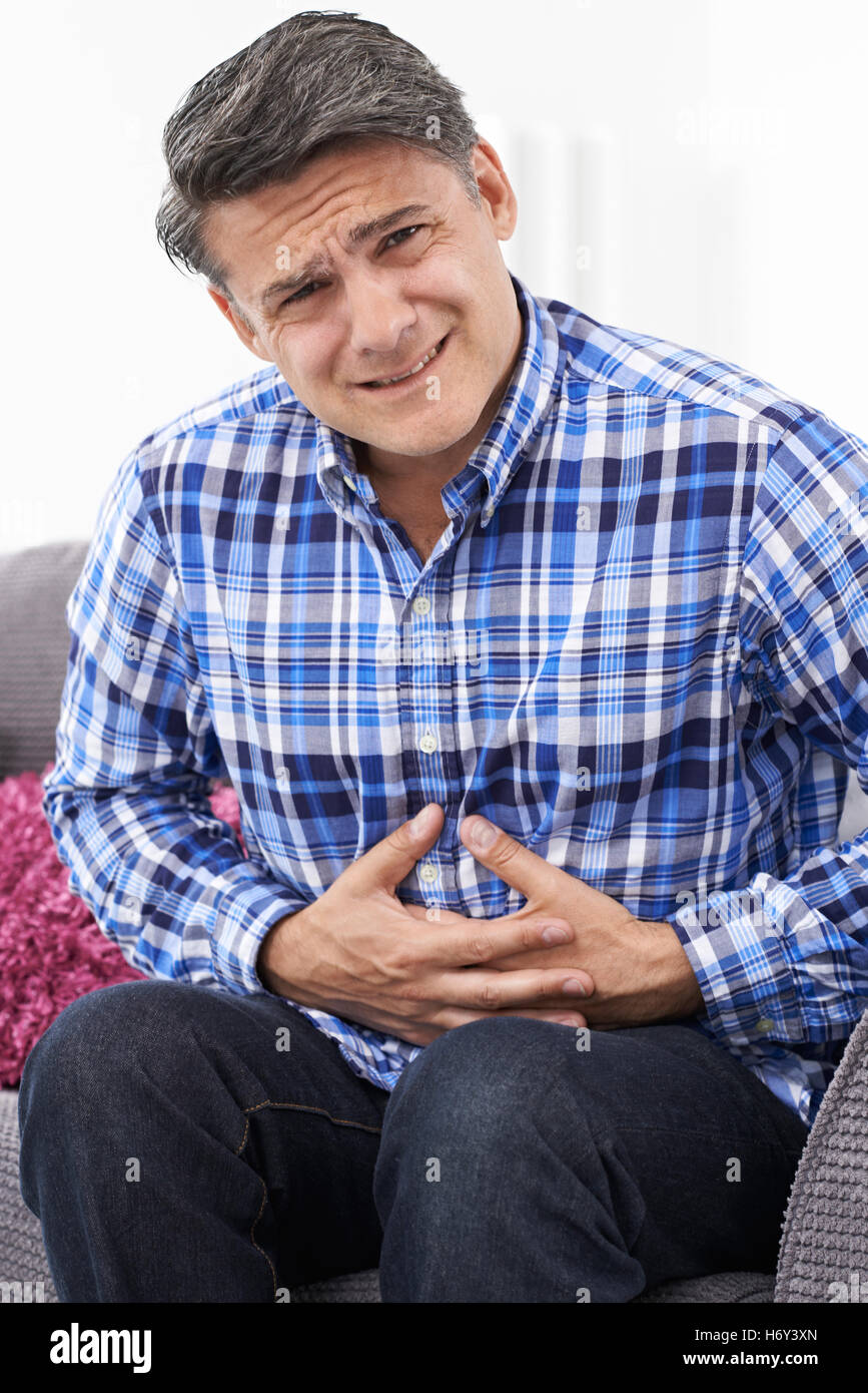 Uomo maturo che soffrono di dolore allo stomaco a casa Foto Stock