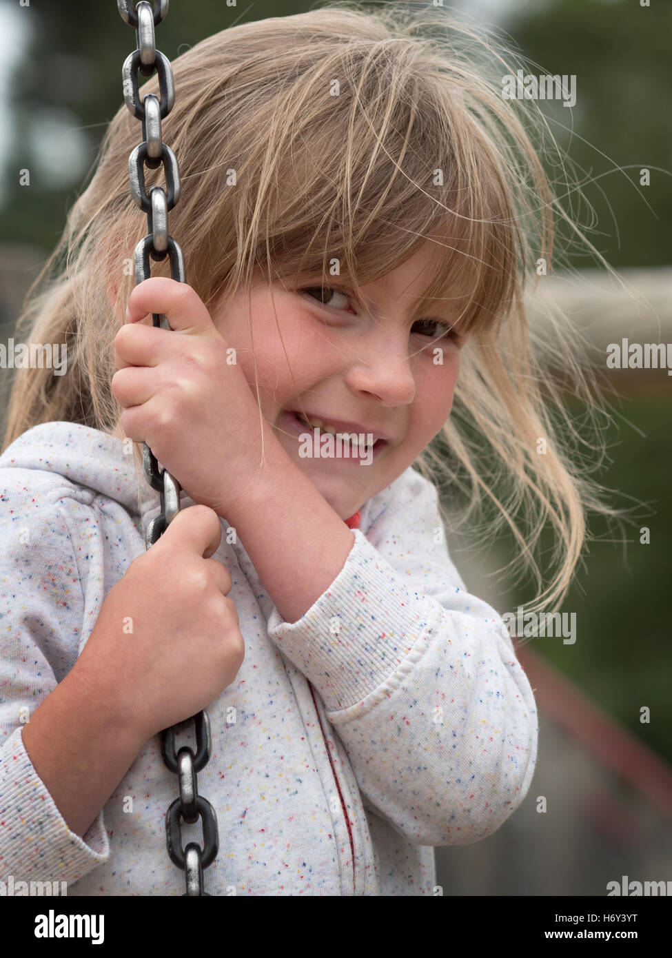 Giovani 6 anno vecchia ragazza a suonare e che pongono in un parco giochi. Foto Stock