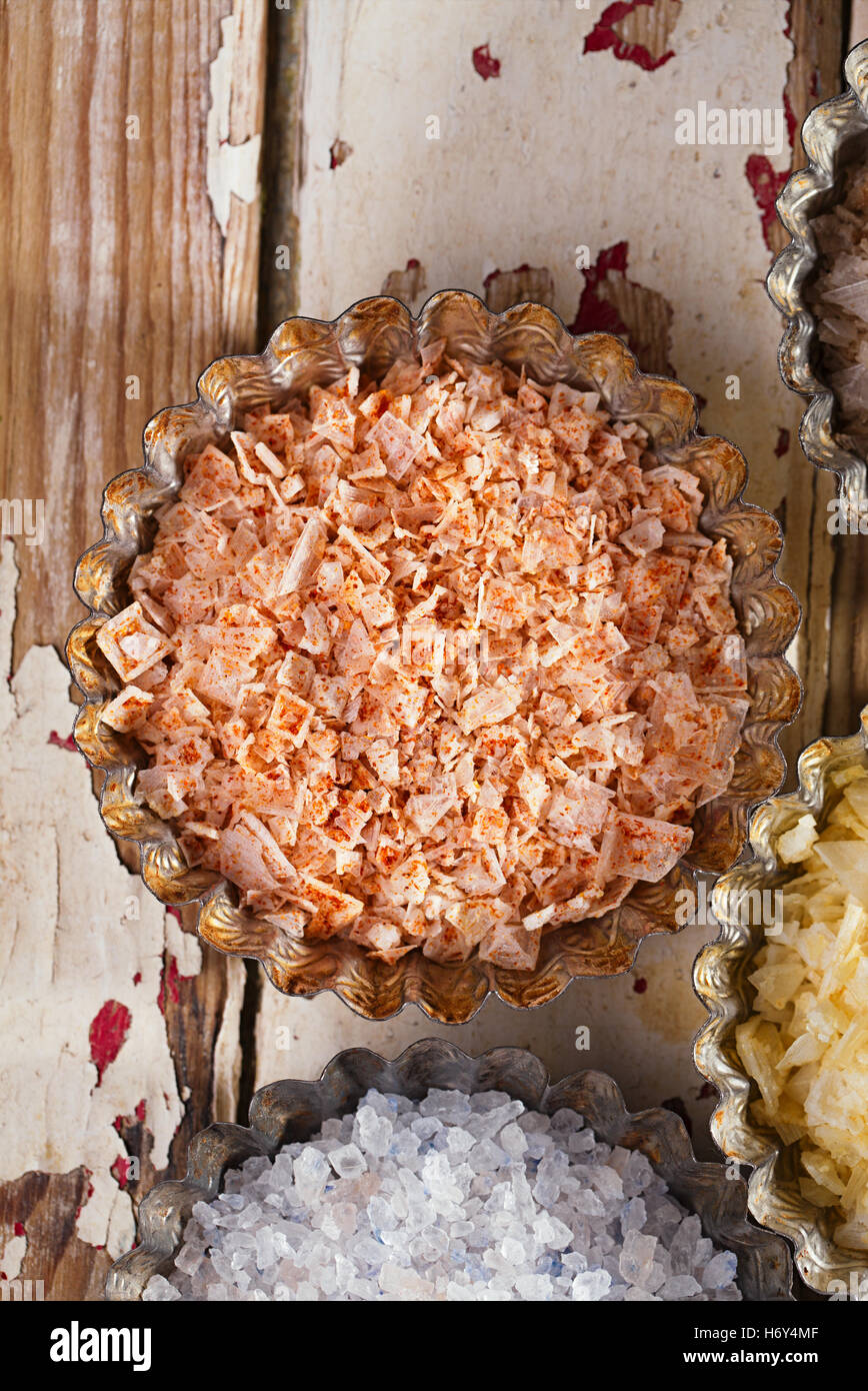 Sale marino fiocchi - Peperoncino rosso n sul vecchio legno dipinta sullo sfondo Foto Stock