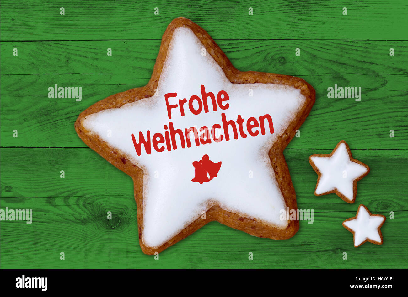 Frohe Weihnachten (in tedesco Buon Natale) cannella stella sul legno verde dello sfondo. Foto Stock