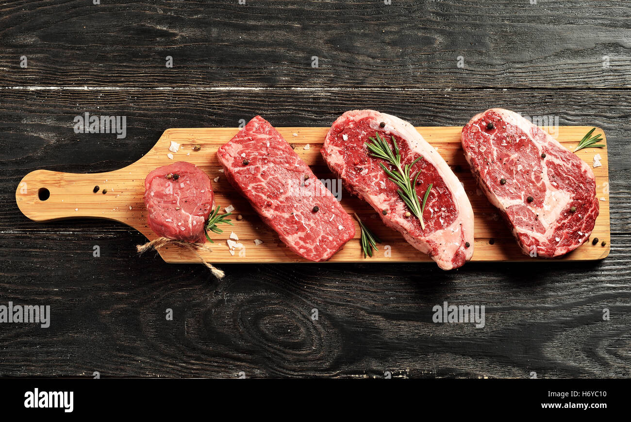 Fresche Materie Prime nero Angus bistecche sulla tavola di legno: Filetto, Denver tagliare, Controfiletto, occhio di nervatura Foto Stock