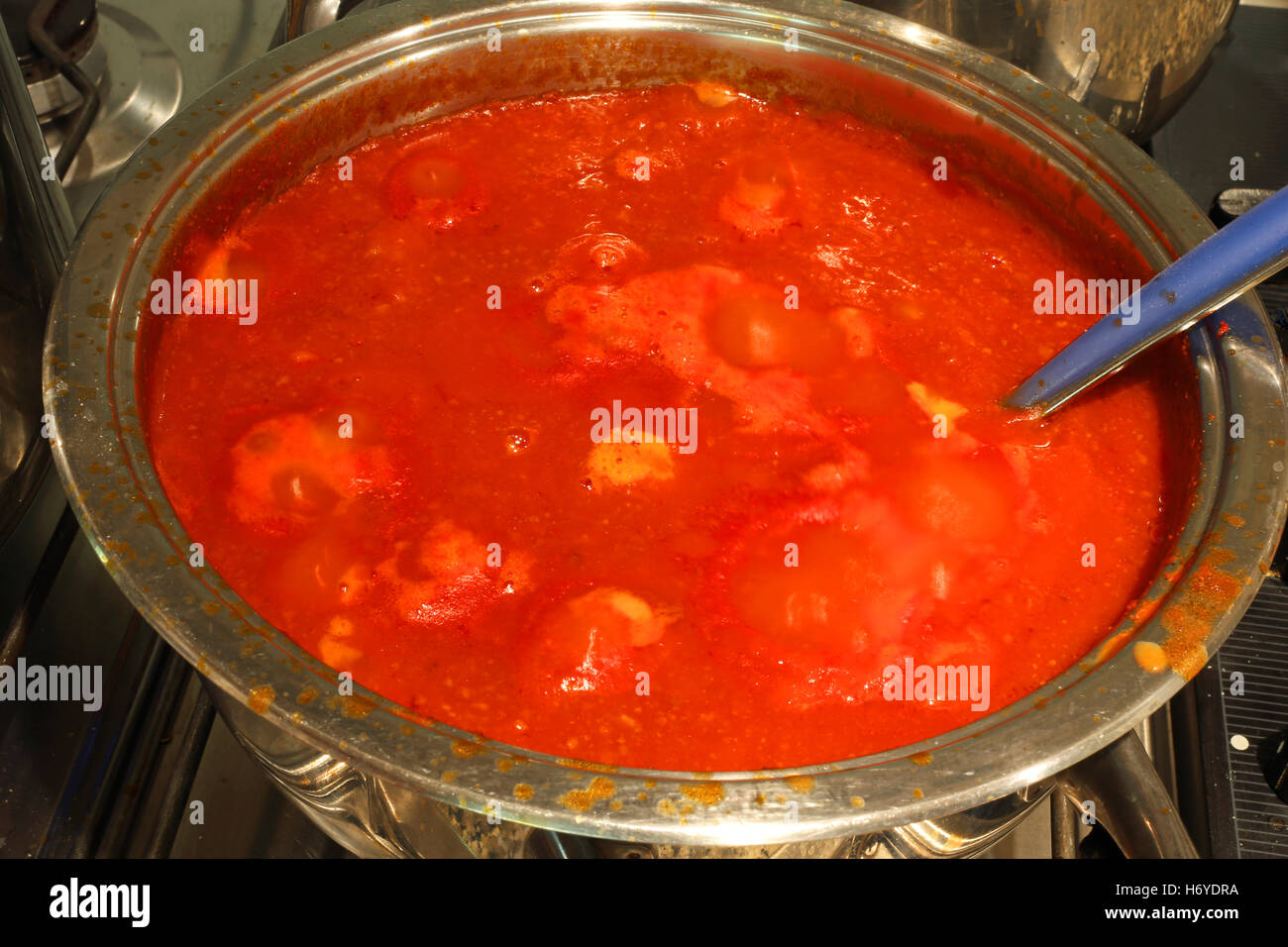 Pentola piena di salsa di pomodoro rosso nella cucina di una casa italiana Foto Stock