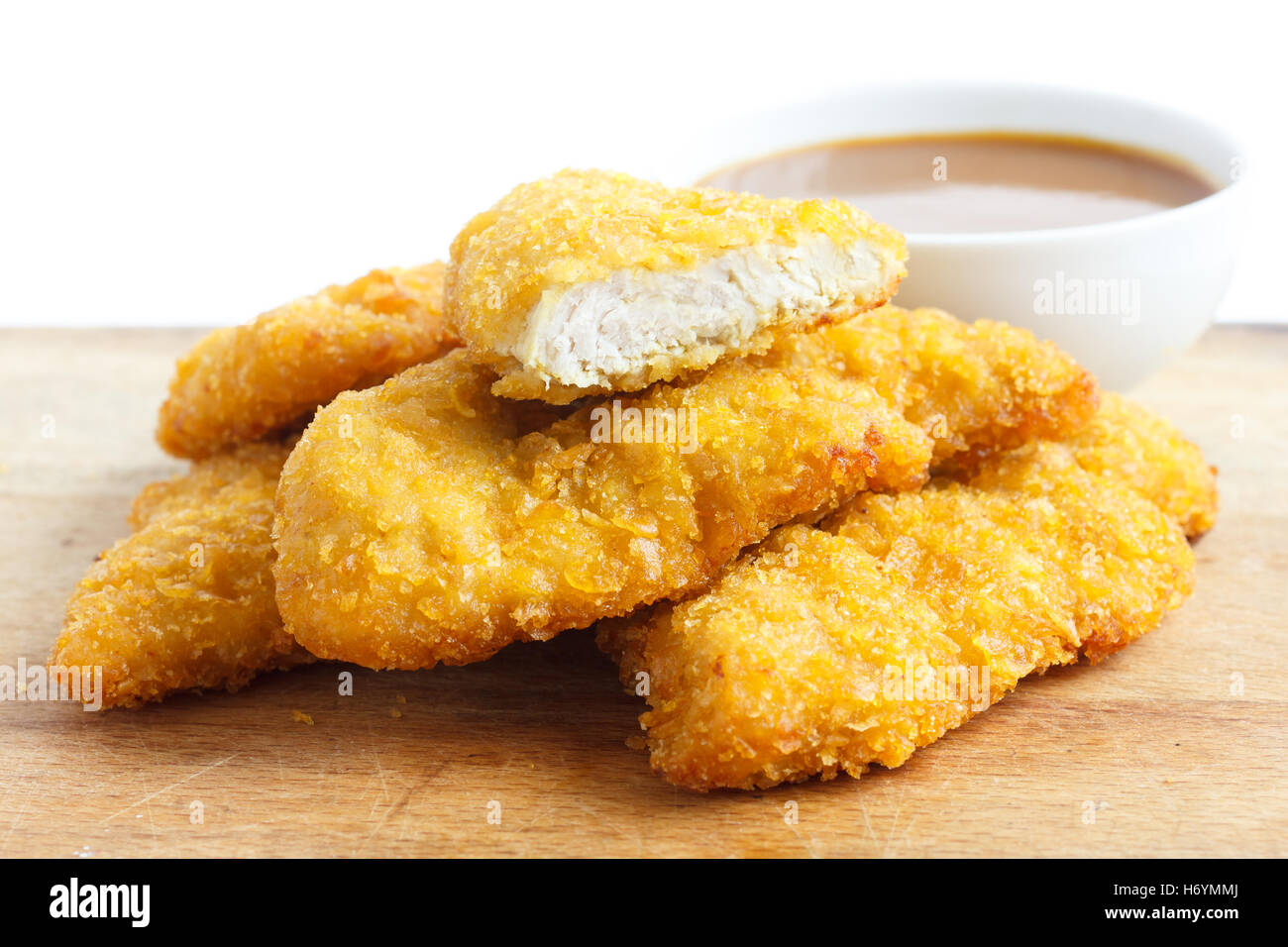 Golden Fried Chicken strisce sul pannello di legno. Curry dip. Foto Stock