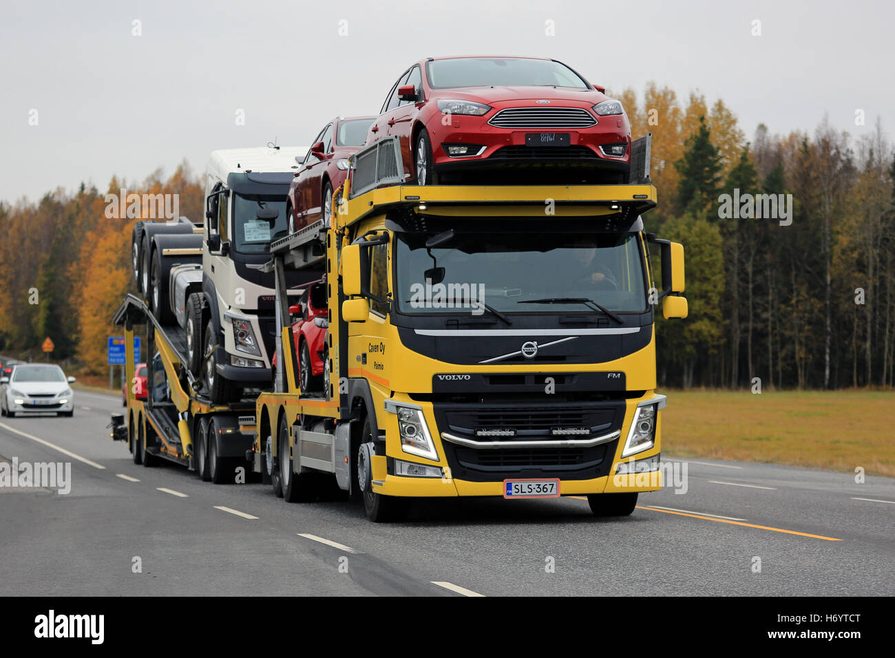 KAARINA, Finlandia - 14 ottobre 2016: Giallo VOLVO FM auto transporter cale nuove vetture lungo l'autostrada in autunno. Foto Stock