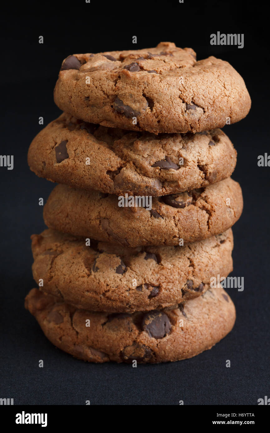 Pila di biscotti con scaglie di cioccolato sul grigio scuro tessuto. Foto Stock