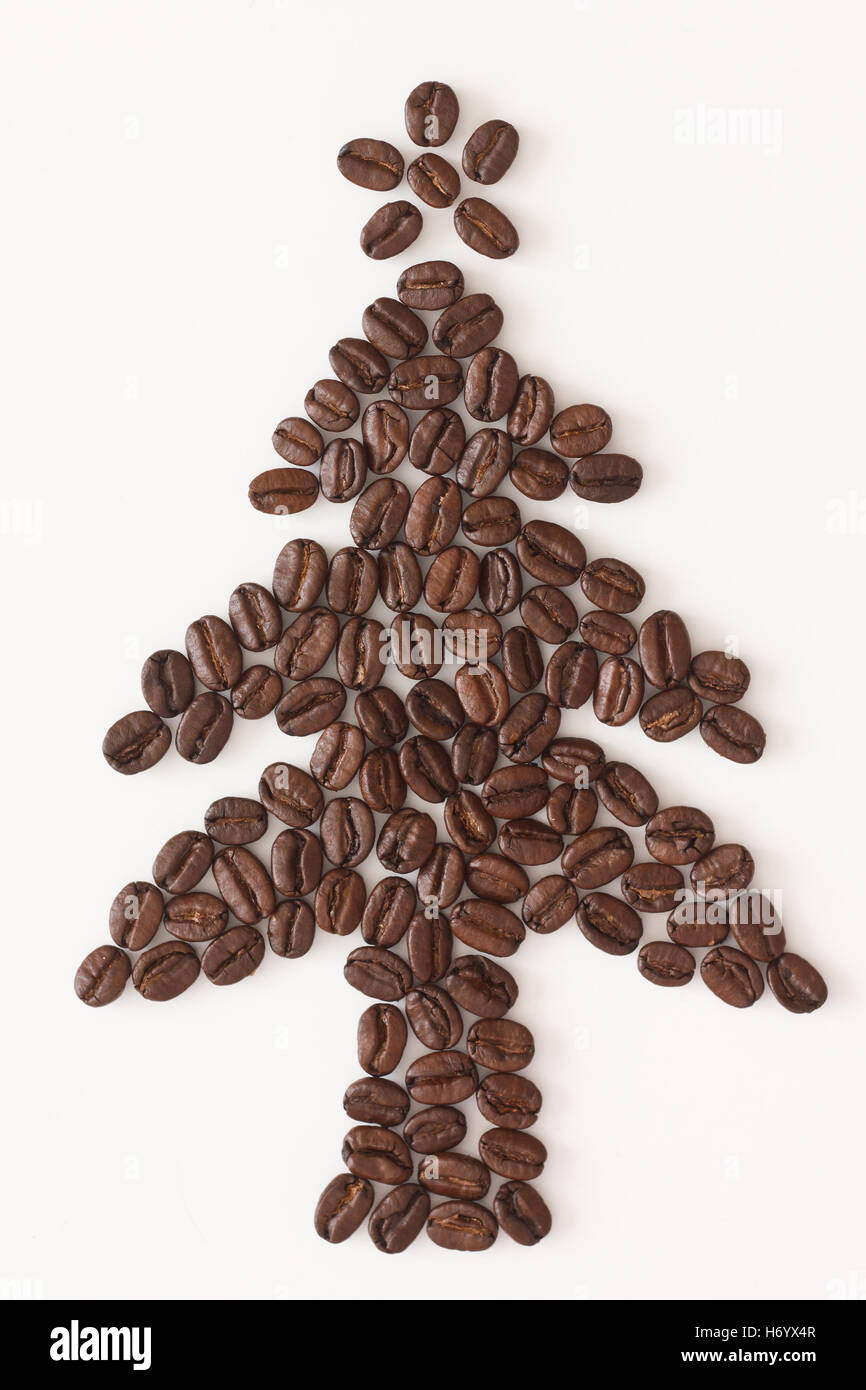 I chicchi di caffè conformato come un albero di natale con una stella decorativo su bianco Foto Stock