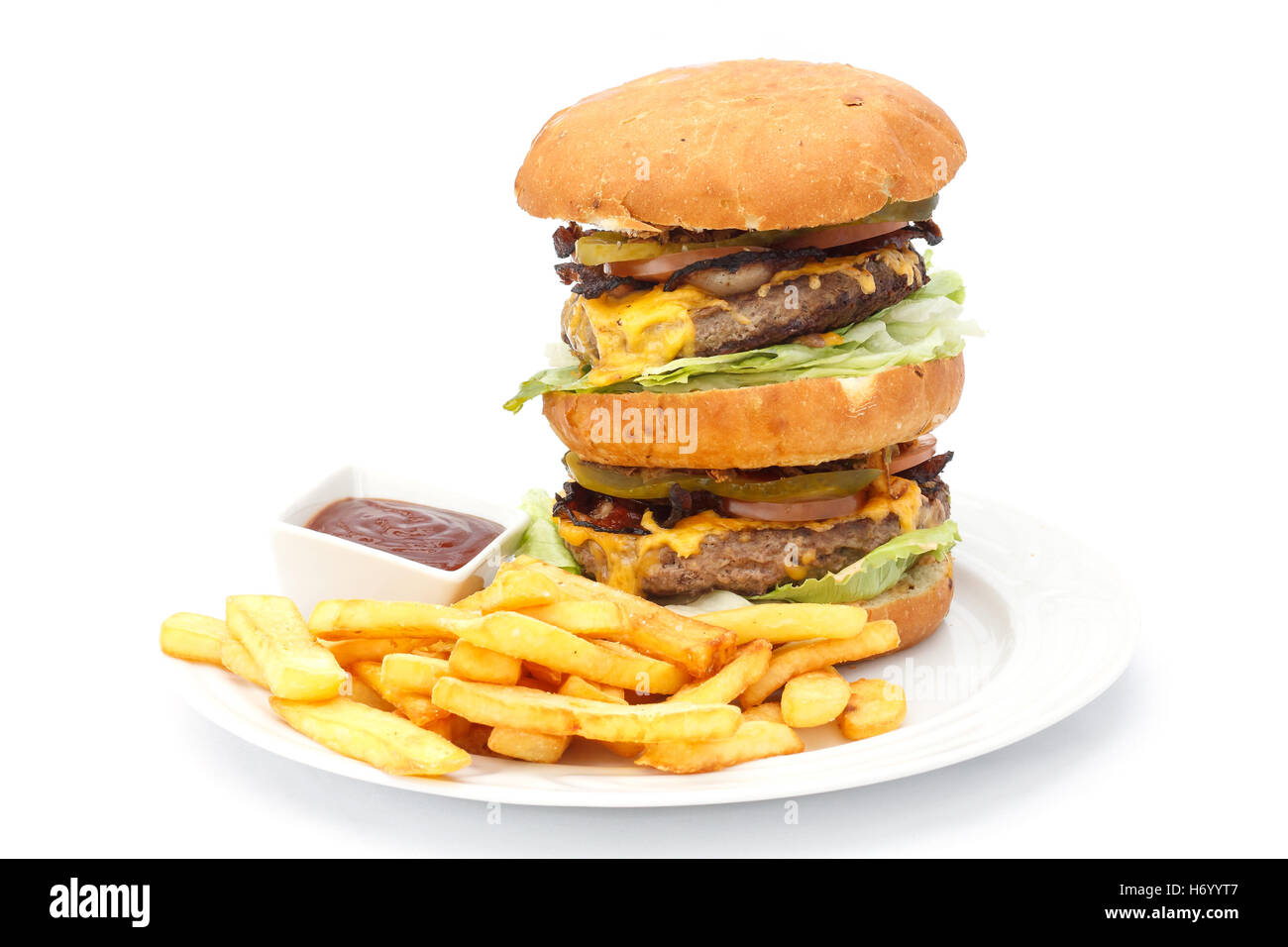 Doppio formaggio hamburger e patatine con ketchup su una piastra bianca. Foto Stock