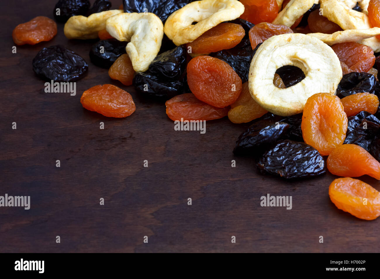 Pila di frutta secca mista su legno scuro. In prospettiva con spazio per il testo. Foto Stock