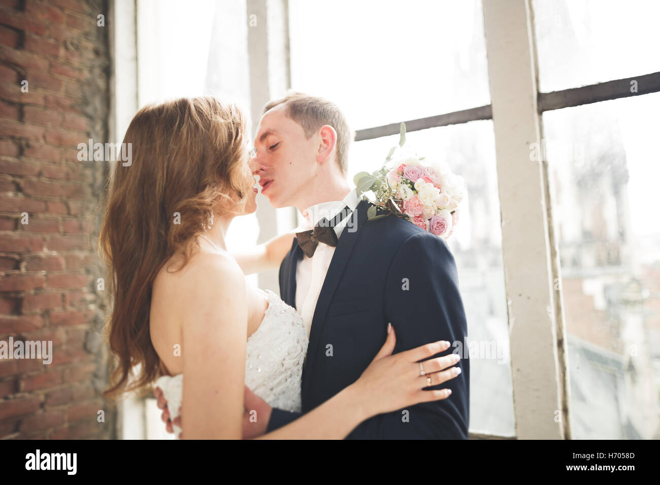 Bella ed elegante sposi baciando e abbracciando sullo sfondo vista panoramica della città vecchia Foto Stock