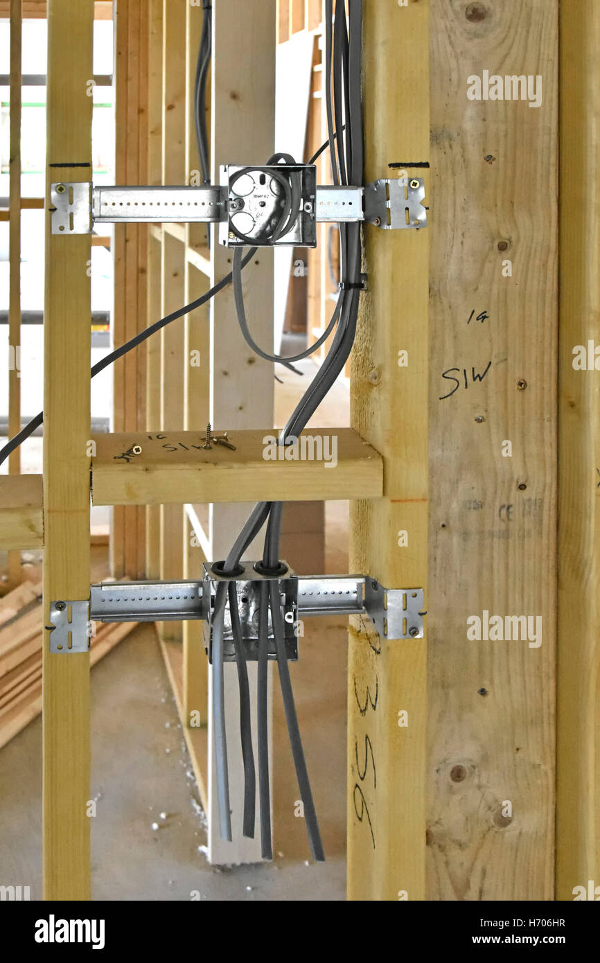 La compenetrazione della staffa di fissaggio della scatola e accessori con i cavi elettrici installati in partizioni di legname nella nuova struttura di legno UK Casa Passiva Foto Stock