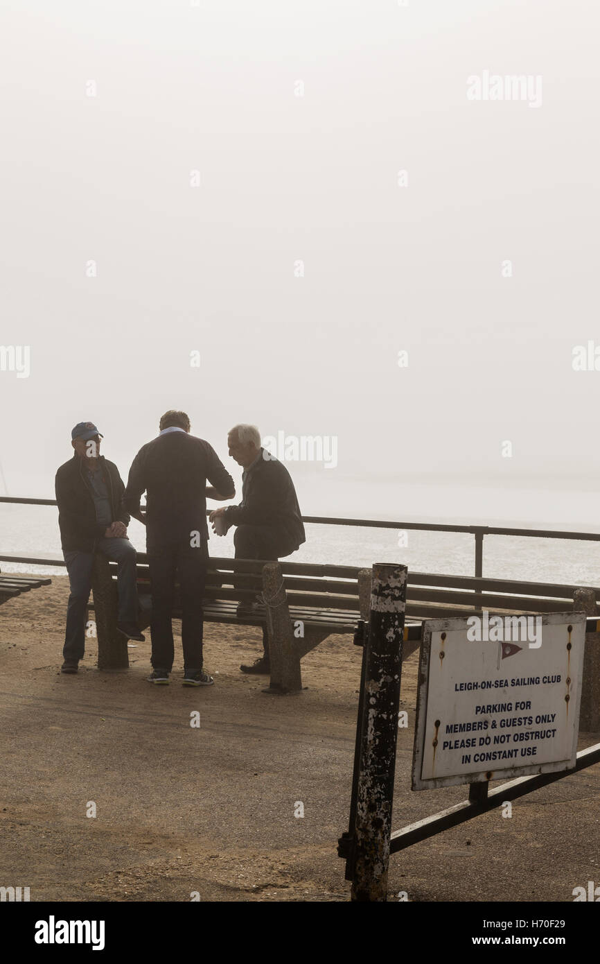 Un gruppo di tre persone di mezza età gli uomini a parlare su Foschia mattutina Foto Stock