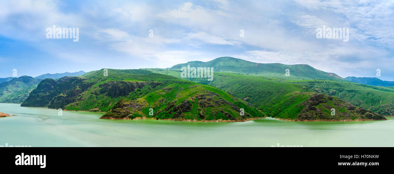 Panorama delle pendici dei monti Qurama ed il serbatoio Achangaran sul primo piano, Uzbekistan. Foto Stock
