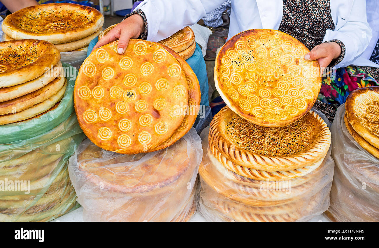 Il mercante dimostra lochira (tradizionale pane piatto), che è particolarmente gustosa nella valle di Fergana regione, Pungan, Uzbekist Foto Stock
