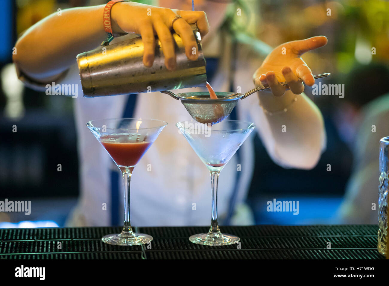 Un cocktail maker barman rendendo martini e cocktail al bar Foto Stock