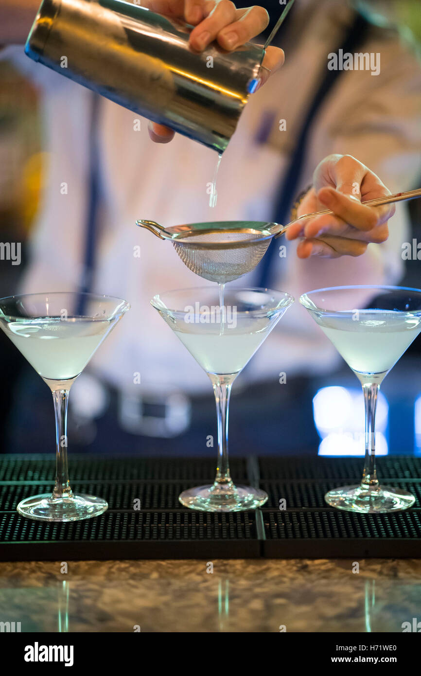 Un cocktail maker barman rendendo martini e cocktail al bar Foto Stock