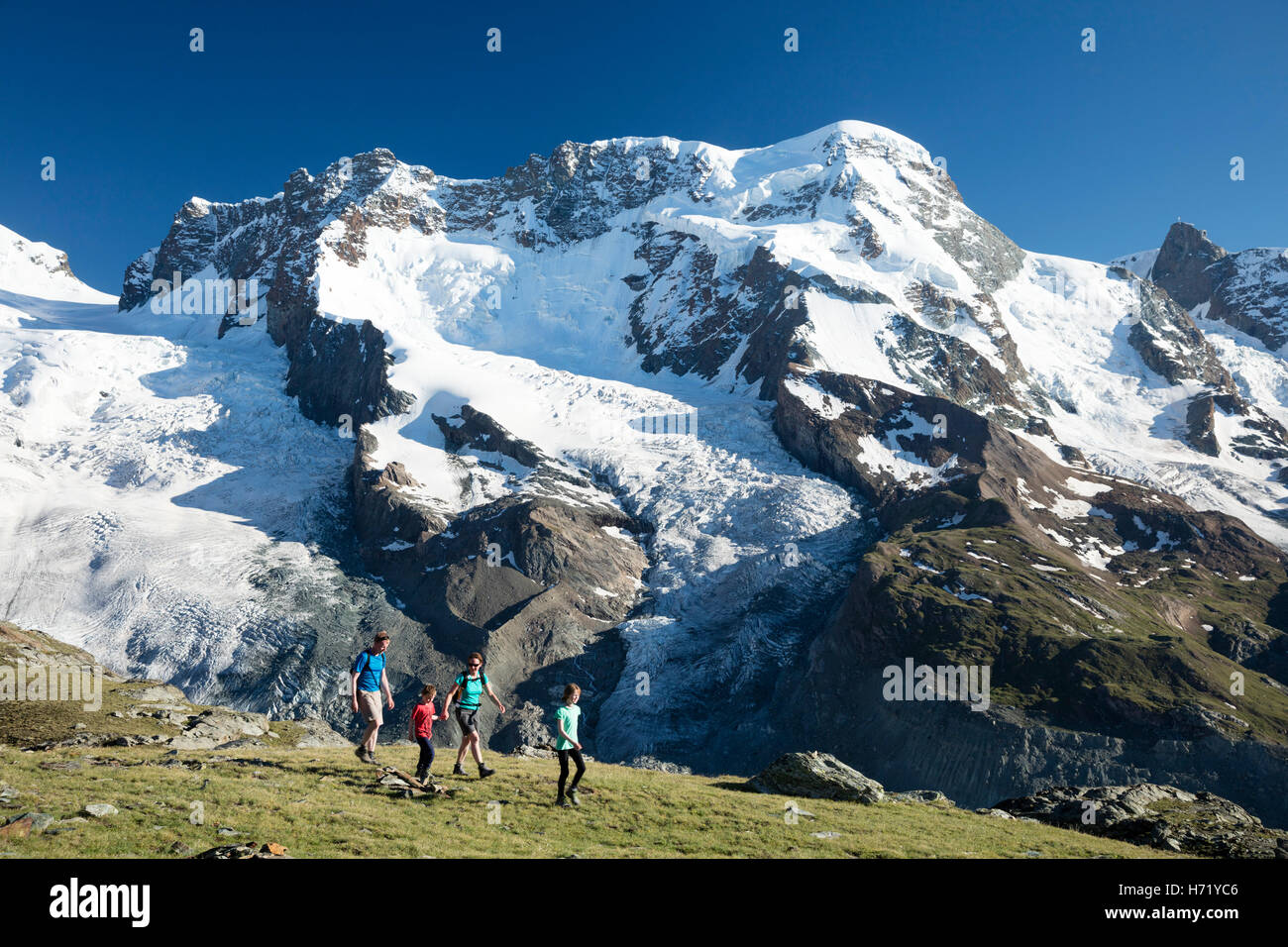 Famiglia escursioni sotto il Monte Rosa, dal Gornergrat. Zermatt, Pennine, Vallese, Svizzera. Foto Stock