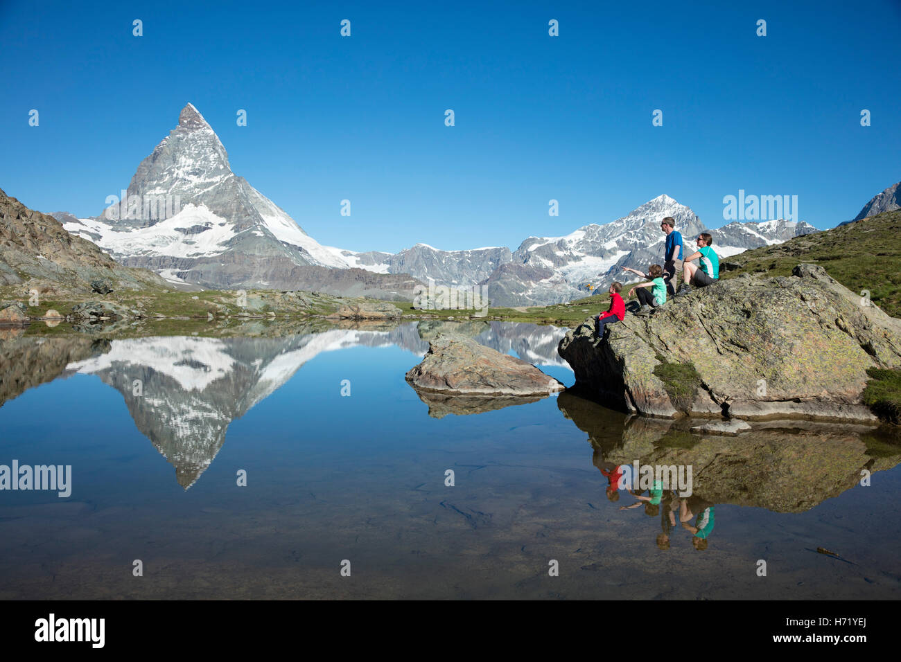 Escursionismo famiglia e Cervino si riflette nel Riffelsee. Zermatt, Pennine, Vallese, Svizzera. Foto Stock