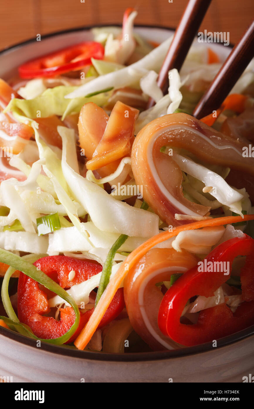 Asian insalata con le orecchie di maiale e le verdure in una ciotola macro verticale. Foto Stock