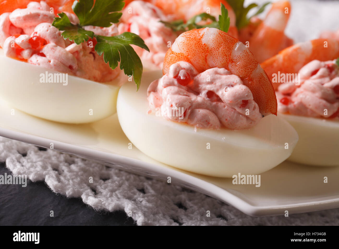 Uova ripiene con gamberetti, crema di formaggio e caviale close-up su una  piastra orizzontale Foto stock - Alamy