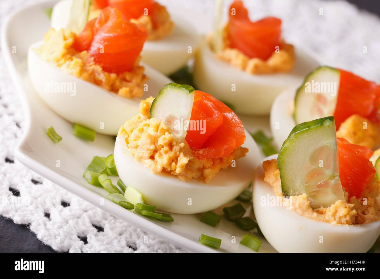 Bellissima cibo: uova ripiene con salmone e cetriolo closeup su una piastra orizzontale. Foto Stock