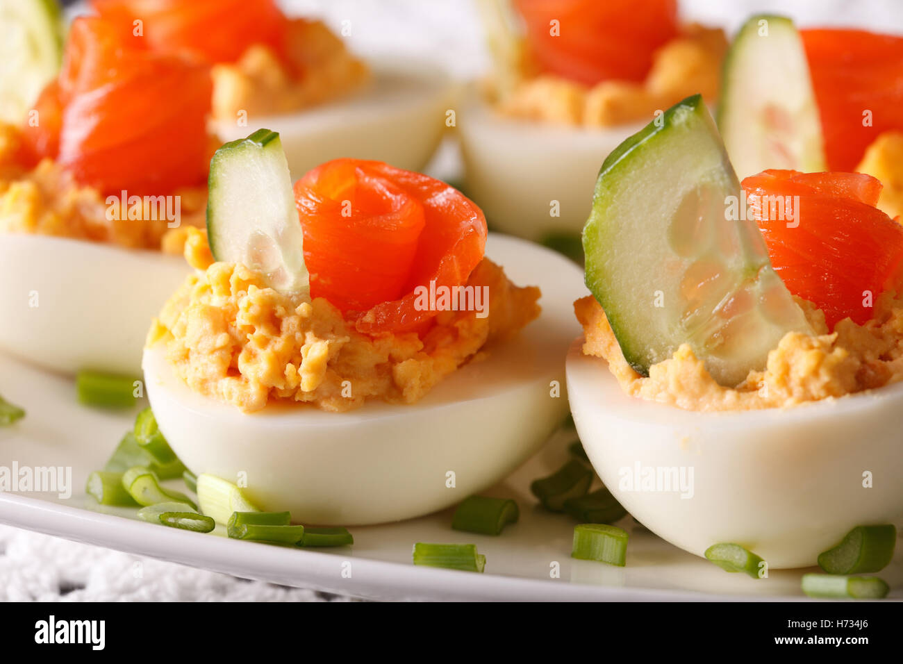 Antipasto di vacanze: uova ripiene con macro di salmone su una piastra orizzontale. Foto Stock
