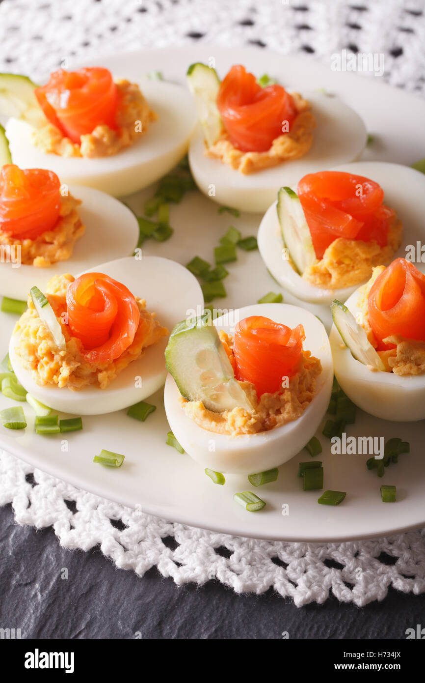 Uova ripiene con salmone e cetriolo closeup su di una piastra verticale. Foto Stock