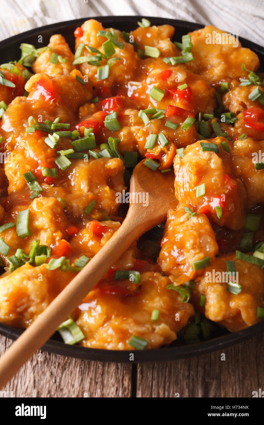 Pollo speziato in salsa di arancia closeup su di una piastra verticale. Foto Stock