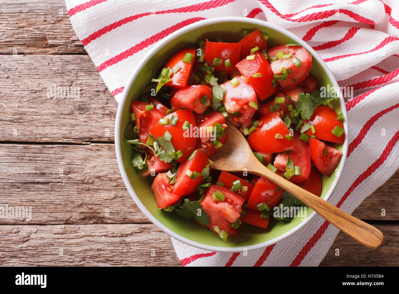 Cibo vegetariano: insalata di pomodoro con cipolla in una ciotola di close-up. Vista orizzontale dal di sopra Foto Stock