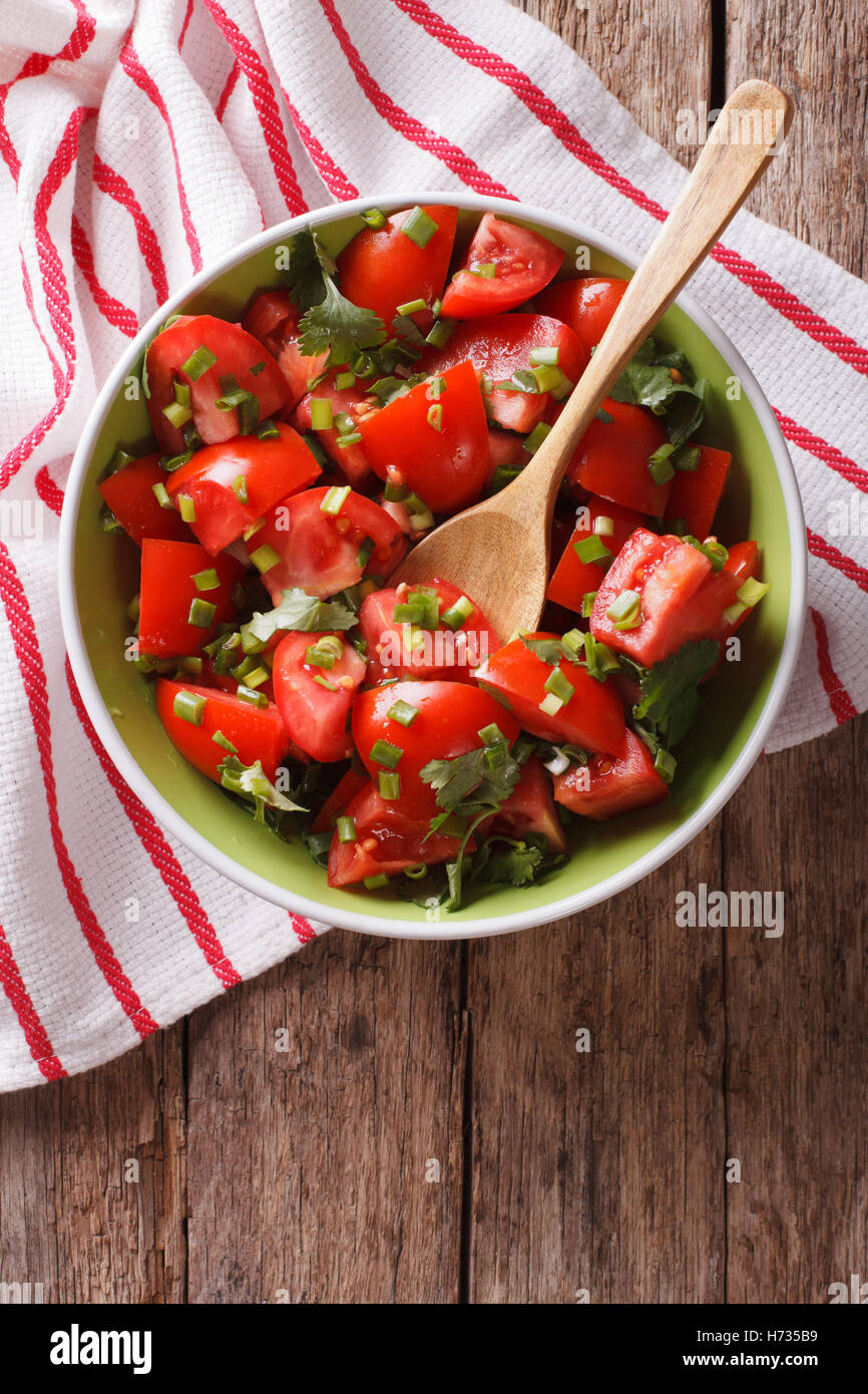 Cibo vegetariano: insalata di pomodoro con cipolla in una ciotola di close-up. vista verticale da sopra Foto Stock