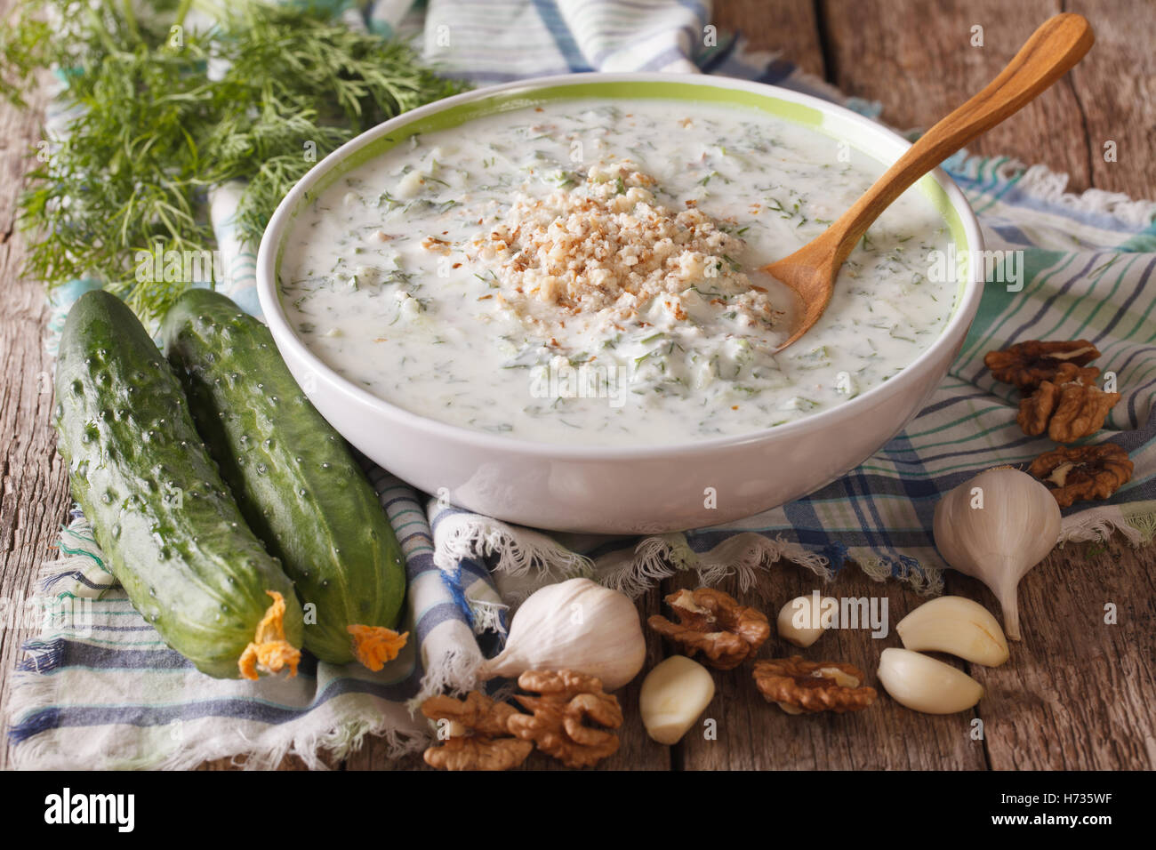 Il bulgaro zuppa fredda tarator vicino fino in una ciotola e gli ingredienti sul tavolo orizzontale. Foto Stock