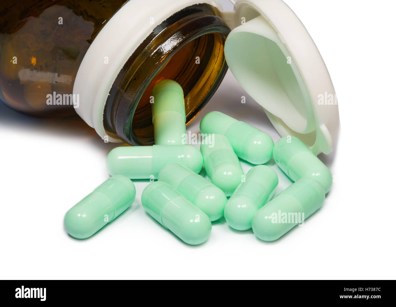 Capsula di medicina e una bottiglia su sfondo bianco Foto Stock