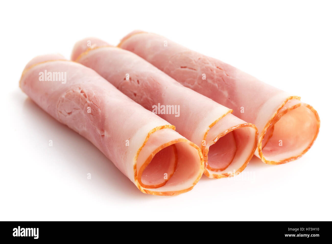 Premio fette di prosciutto disposti su bianco. Foto Stock