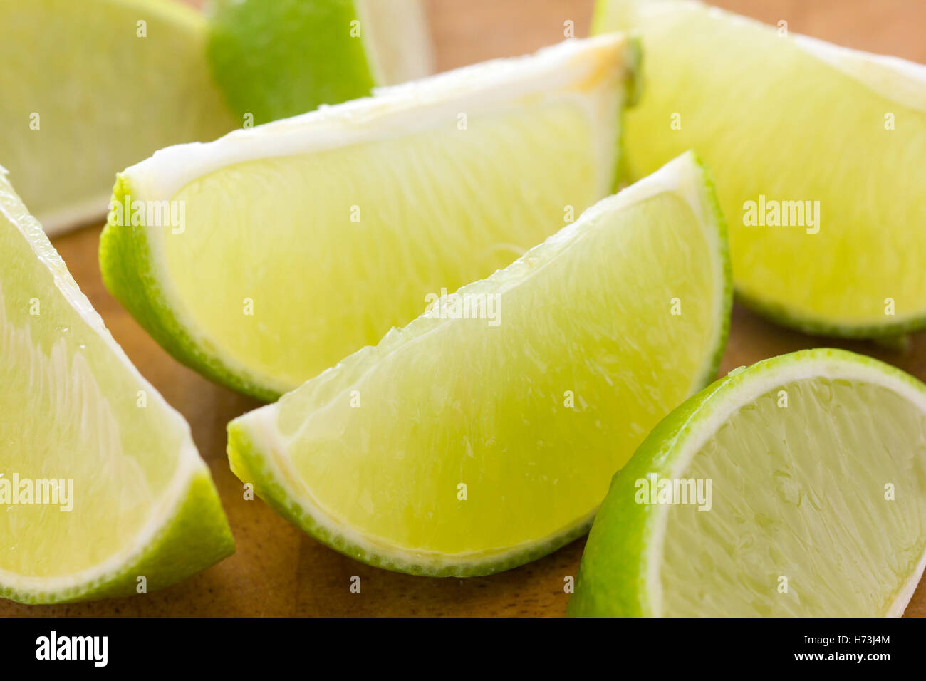 Spicchi di lime disposti su una tavola di legno. Messa a fuoco selettiva. Foto Stock