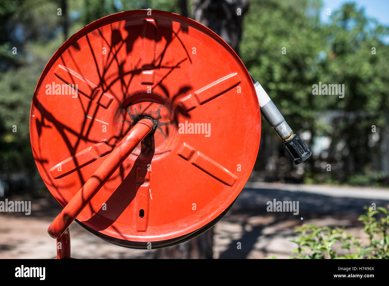 Estintore in un giardino. Alberi e case Foto Stock