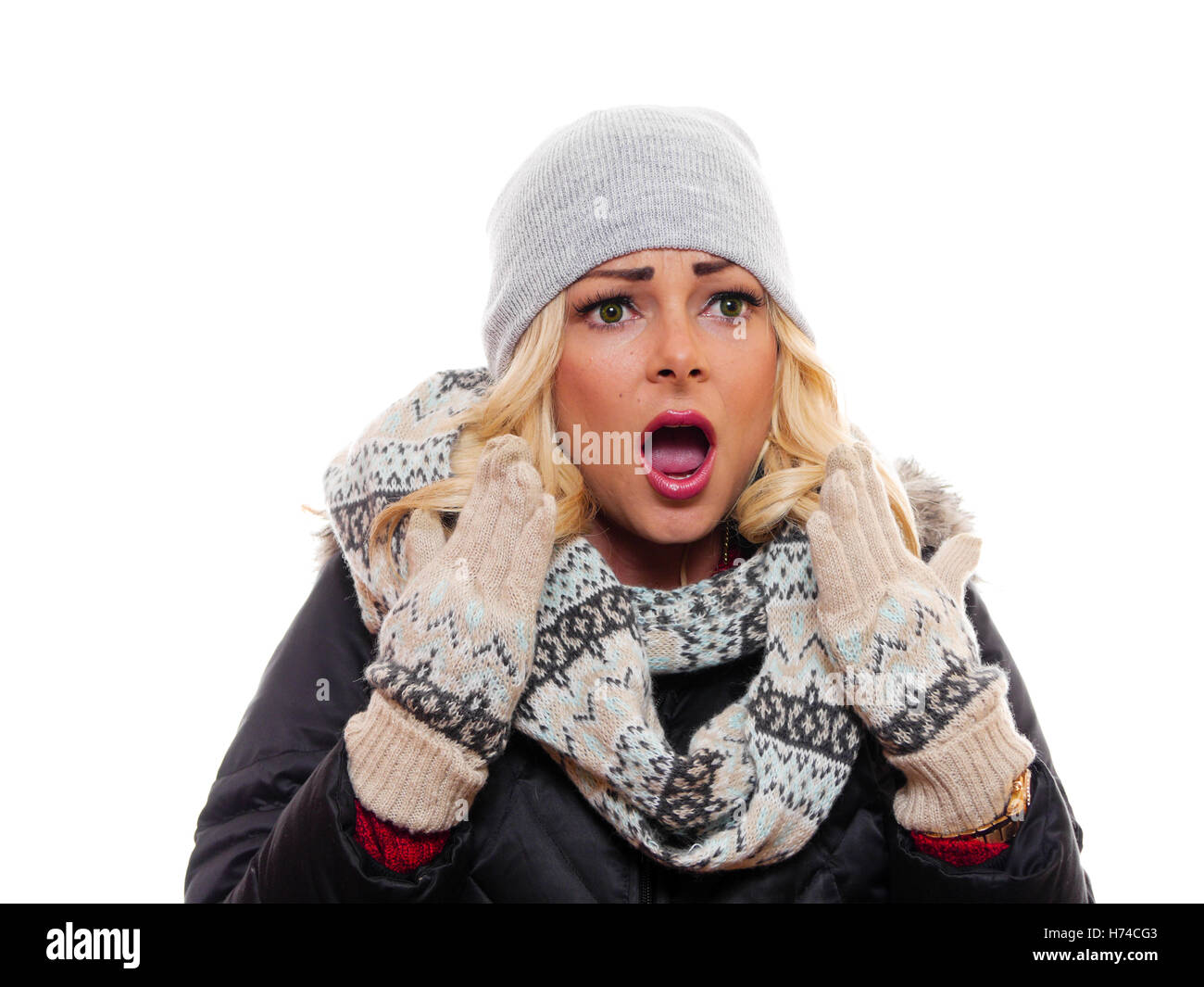 Una donna attraente è in piedi con le mani e la bocca aperta in stato di shock. Foto Stock