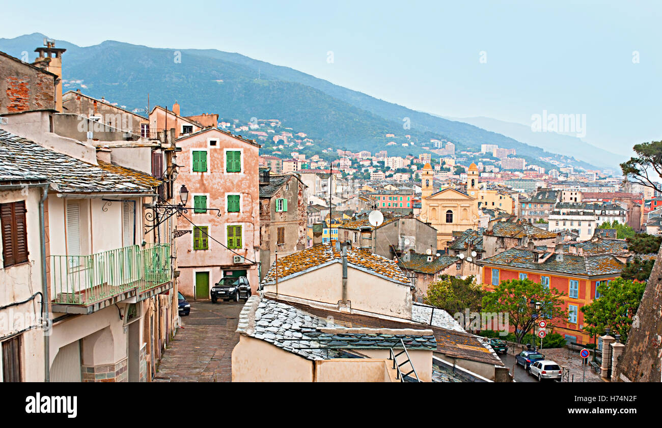 Il paesaggio di Bastia con il bagnato i tetti e le montagne di nebbia dopo il duro autunno pioggia, Corsica, Francia. Foto Stock