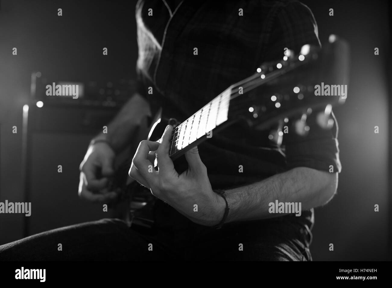 Close up uomo suonare la chitarra elettrica girato in bianco e nero Foto Stock