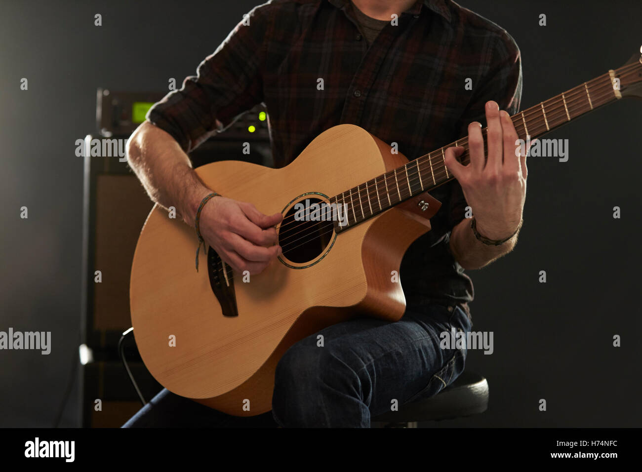 Close up uomo amplificato suonare la chitarra acustica Foto Stock