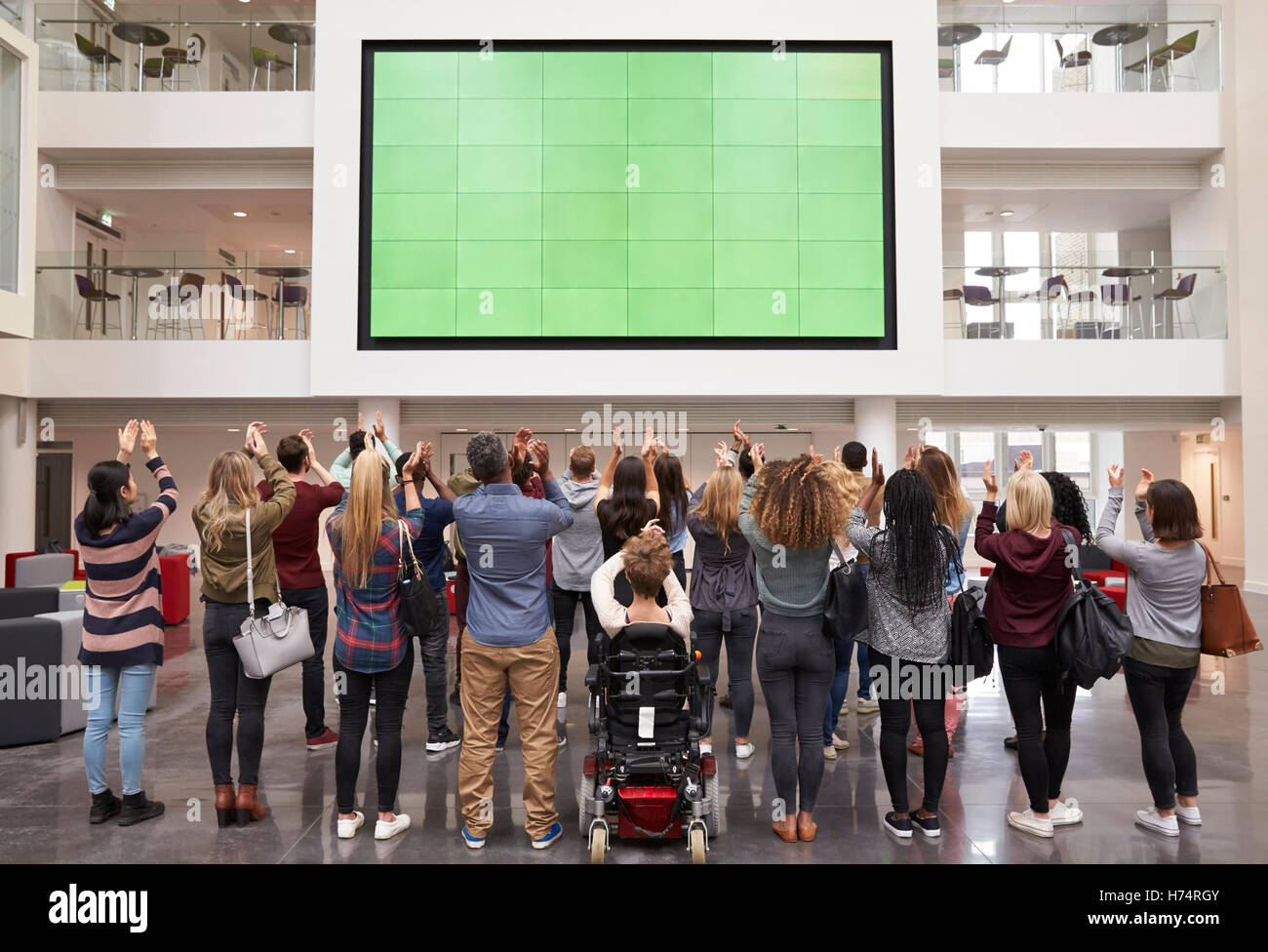 Gli studenti fotografia schermo con telefoni, vista posteriore a piena lunghezza Foto Stock