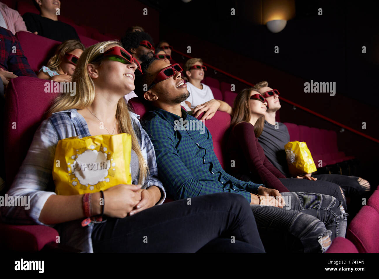 Coppia giovane nel Cinema indossando occhiali 3D per la visione di film Foto Stock