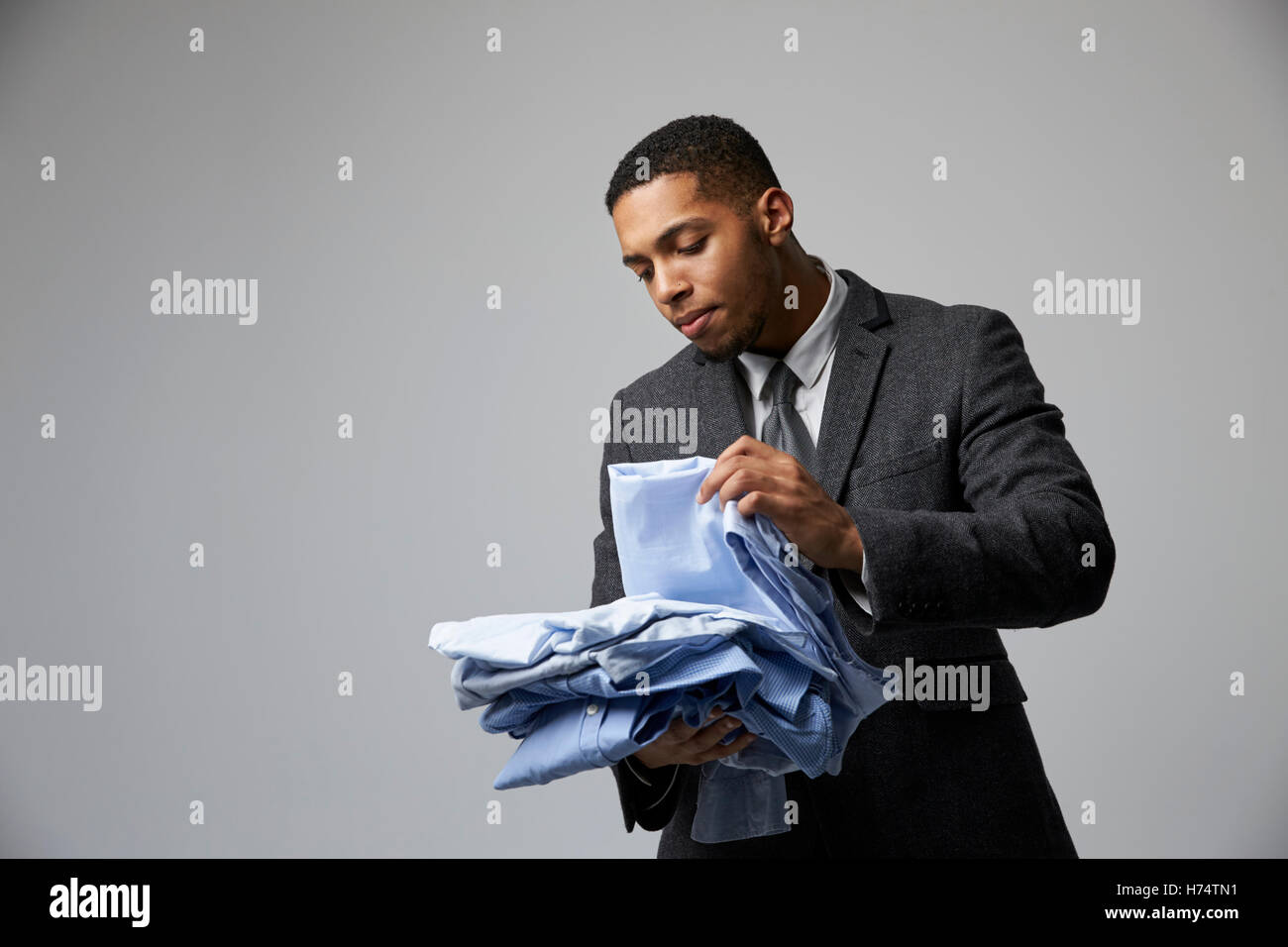 Ritratto in studio di moda maschile acquirente Guardando camicie Foto Stock