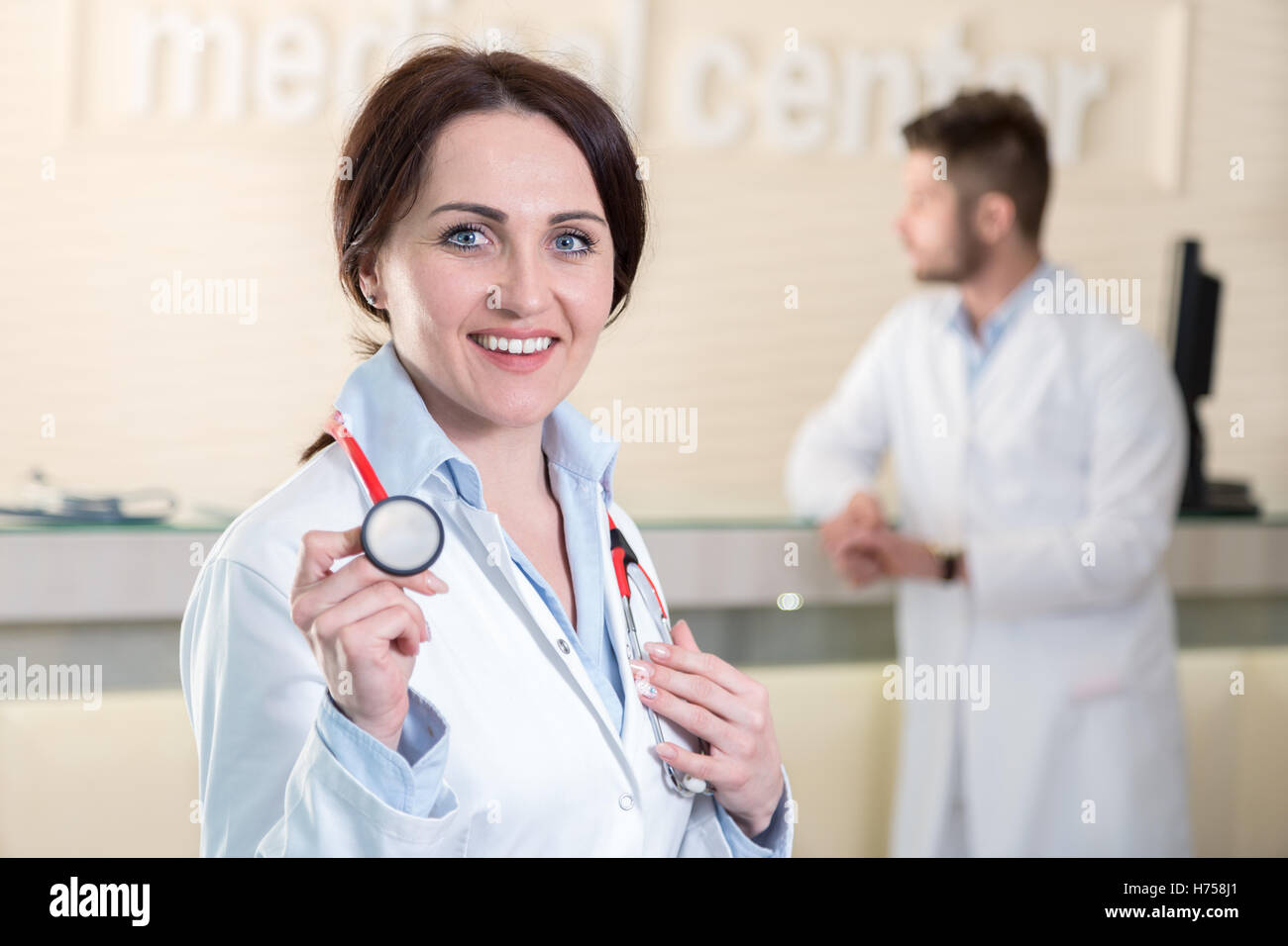 Donna medico tenendo uno stetoscopio nel centro medico Foto Stock