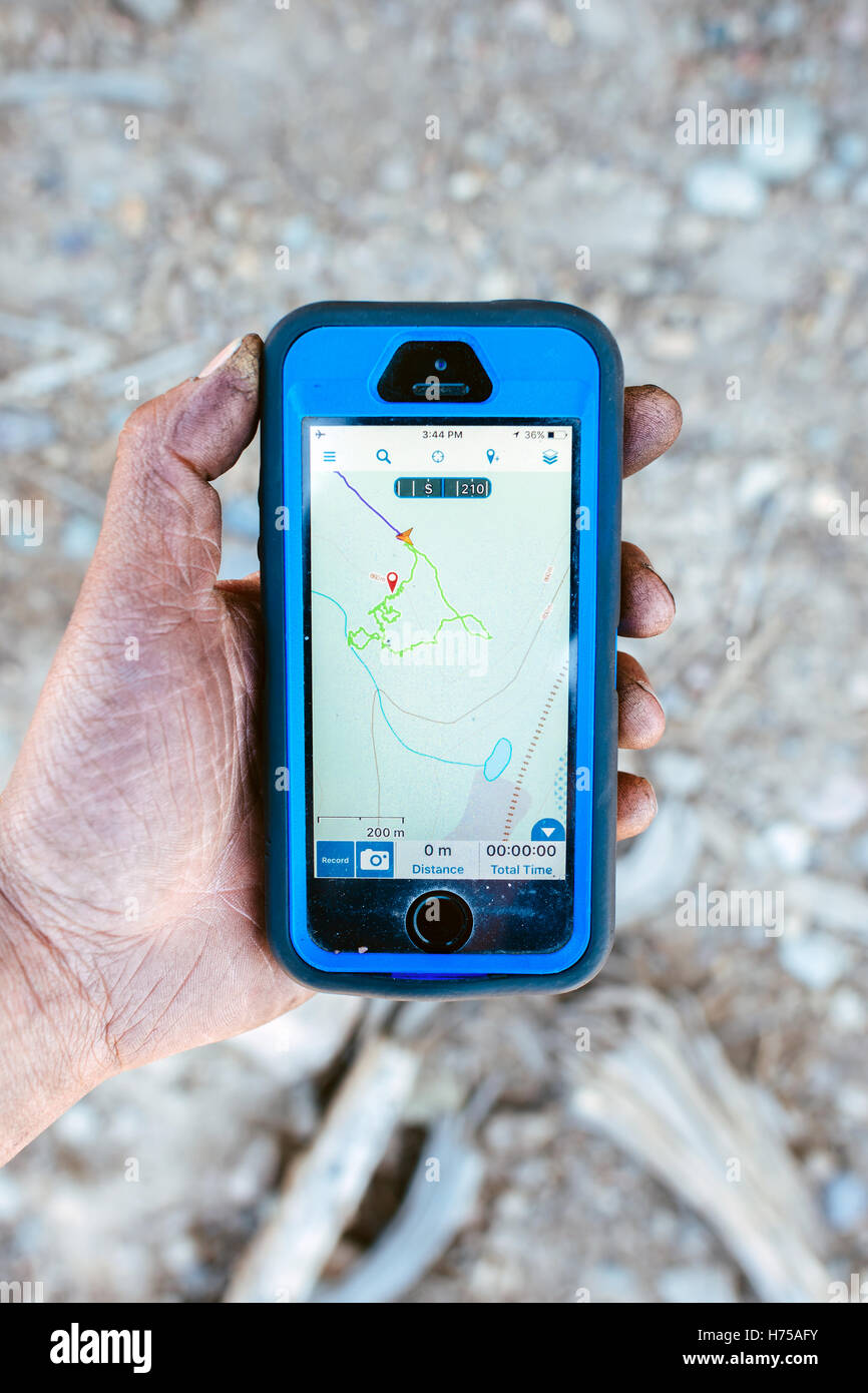 Una donna possiede un iPhone con un app GPS per la navigazione Foto Stock