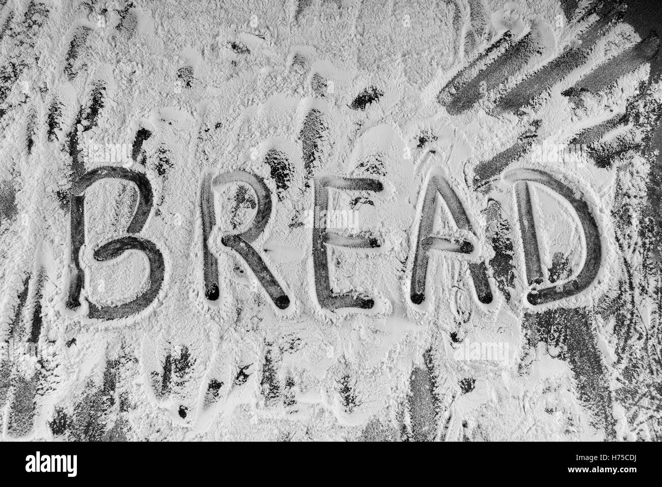 Pane di parola scritta in farina sul tavolo. Foto Stock